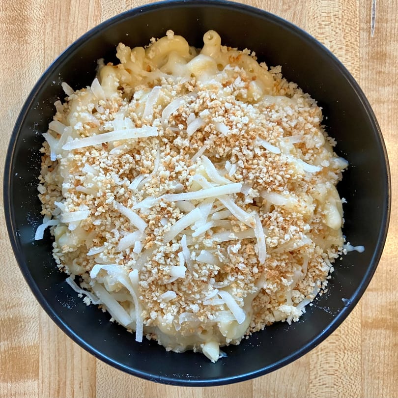 Brookies Cafe's creamy mac and cheese topped with breadcrumbs and shredded cheese in a black bowl.