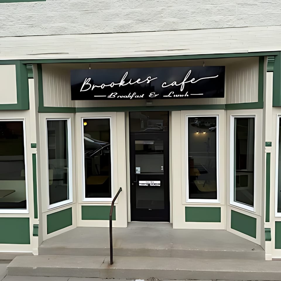 Brookies Cafe storefront with a black sign, green and white trim, and large windows.