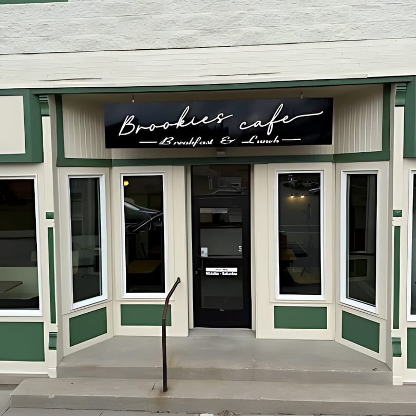 Brookies Cafe storefront with a black sign, green and white trim, and large windows.